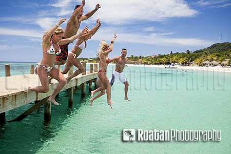 Group of friends jumping off dock stock photo