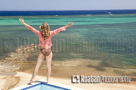 Woman with arms outstretched over sea view stock photo