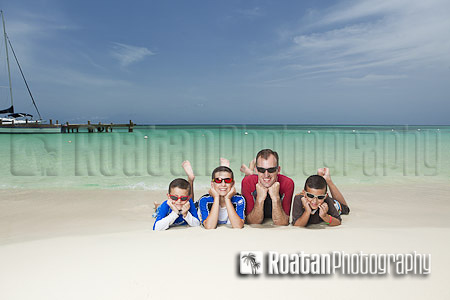 family beach portrait of father and sons resting on tropical beach stock photo